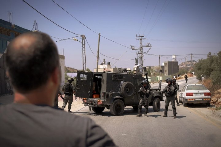 Unidades del ejército de Israel llegan a los alrededores de la vivienda. Enfrente, un vecino tratando de acercarse para defender la casa. Foto: Caterina Albert